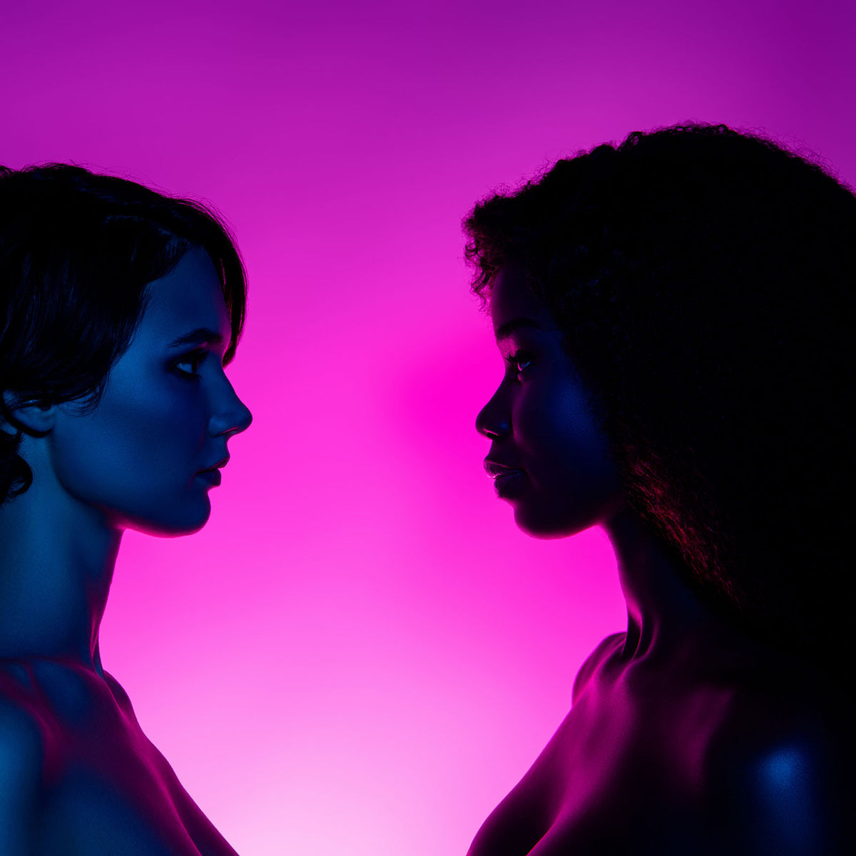 Two women in profile facing each other under coloured light