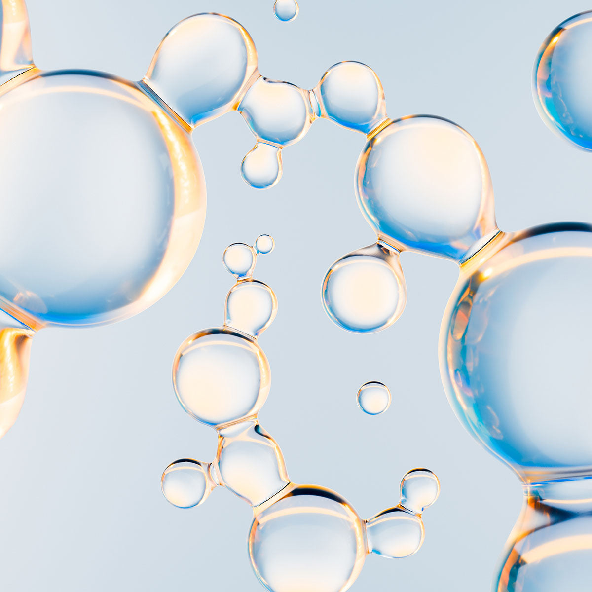 Clear serum droplets of many different sizes suspended against pale blue