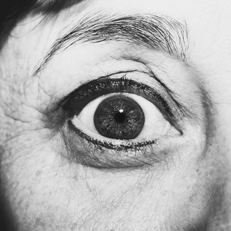 Dramatic black-and-white close-up of an eye and the fine lines around it