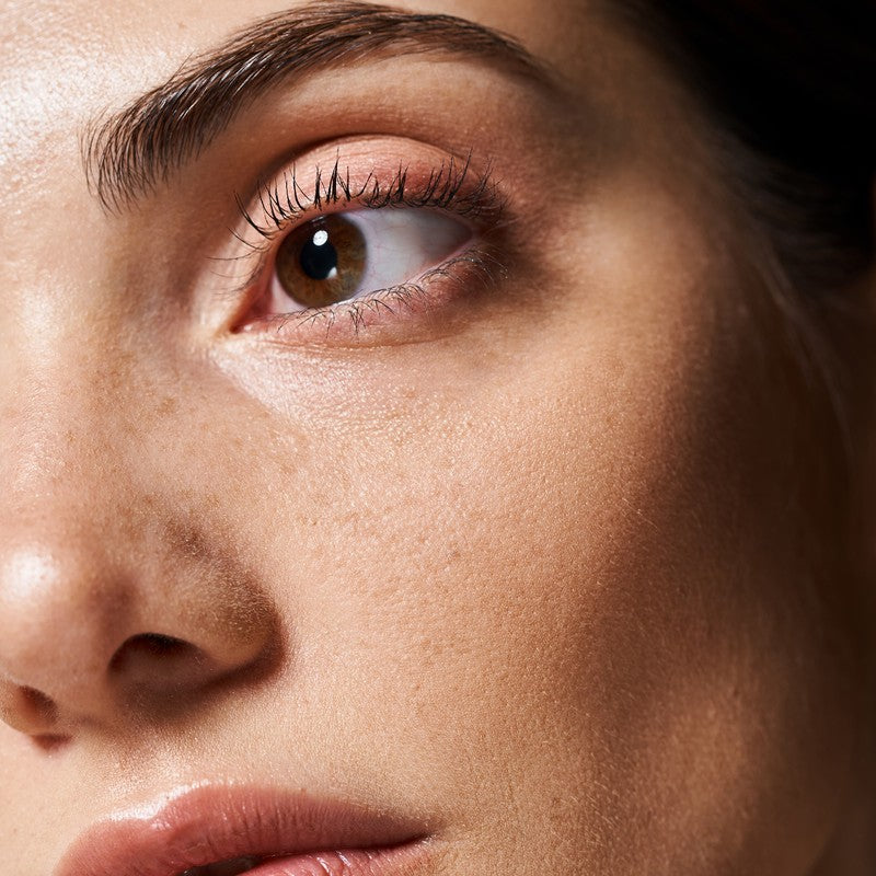 Close-up of a woman's eye and under-eye area in soft natural light